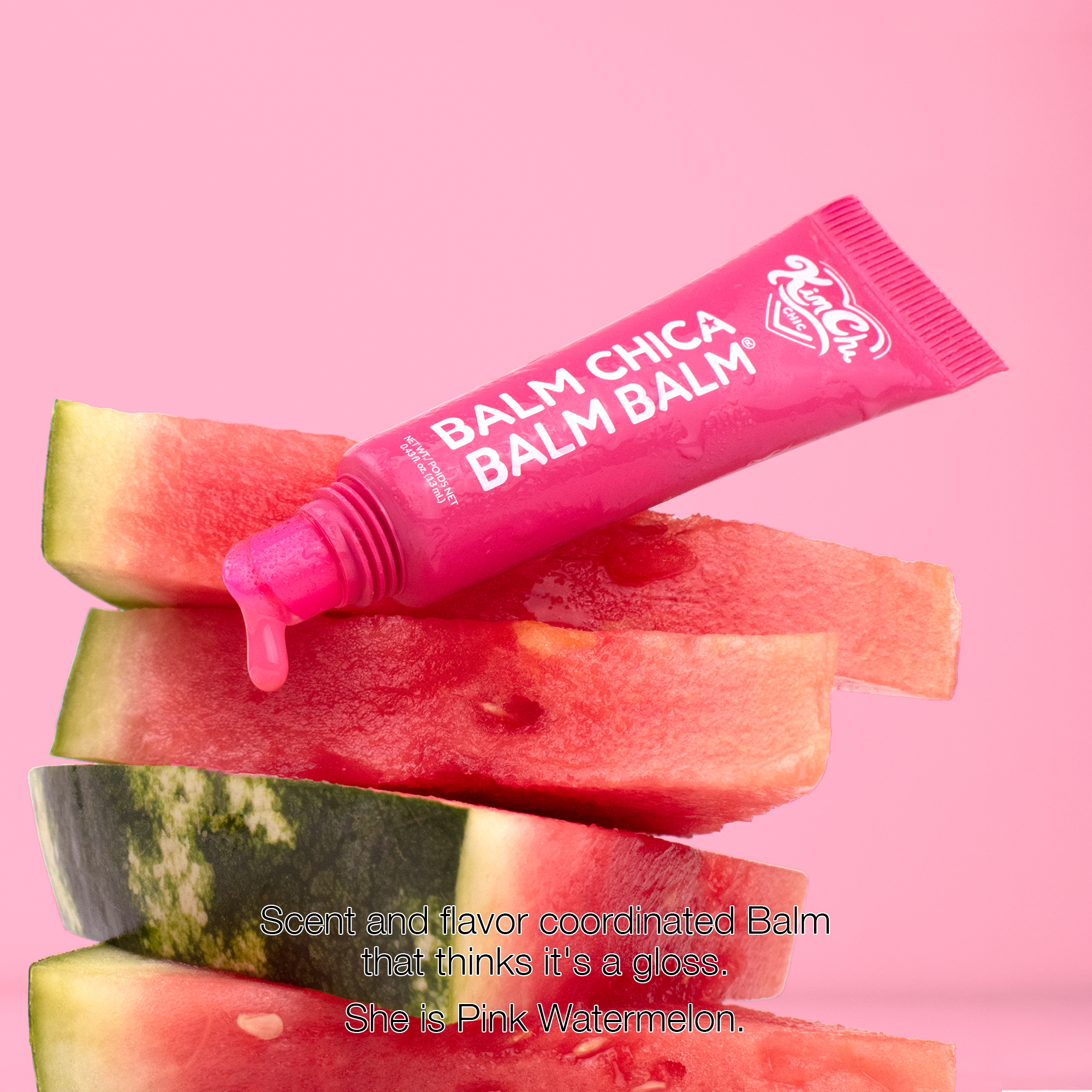 Pink watermelon flavored balm in a tube, styled with fresh watermelon slices.