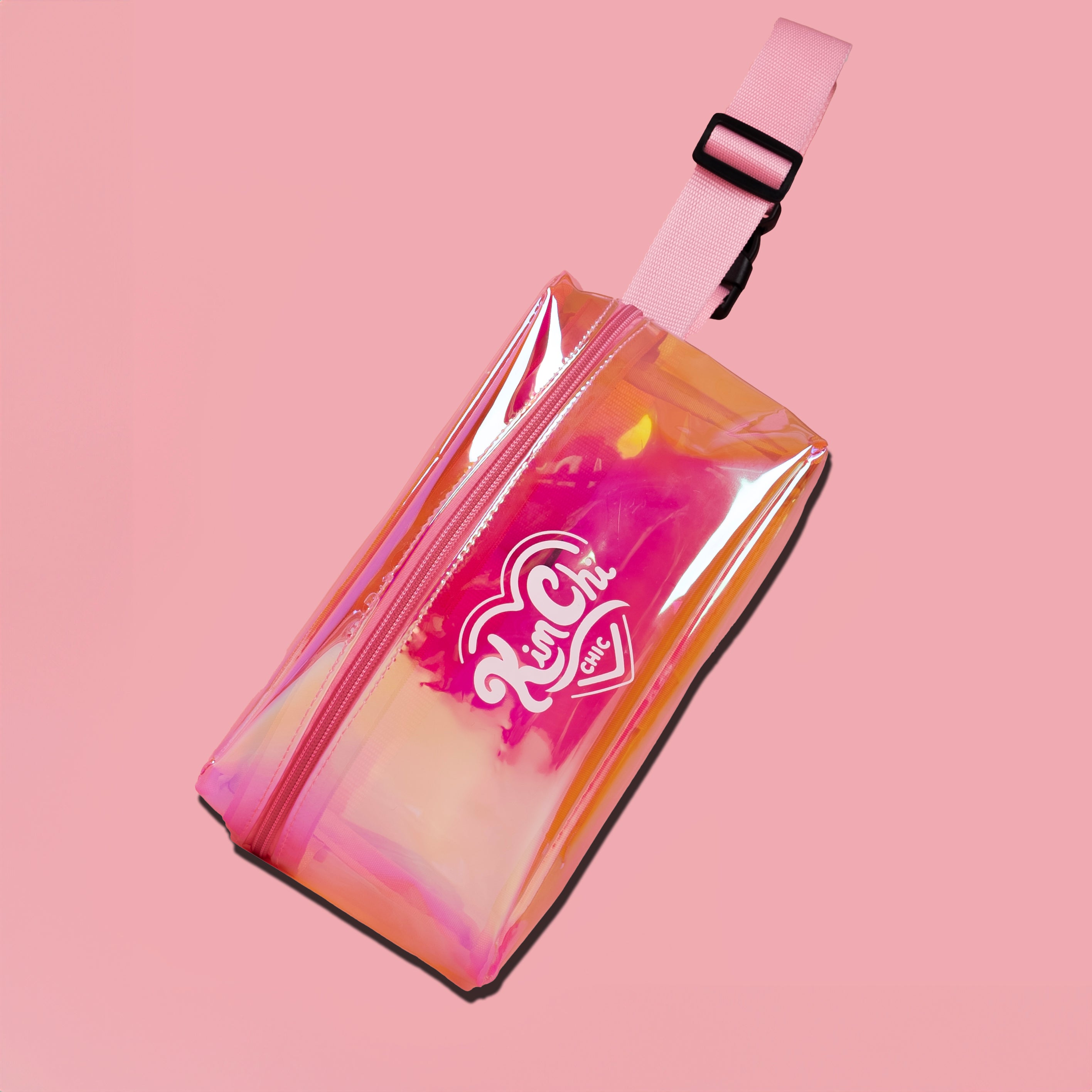 Colorful iridescent bag with pink strap on a pink background.