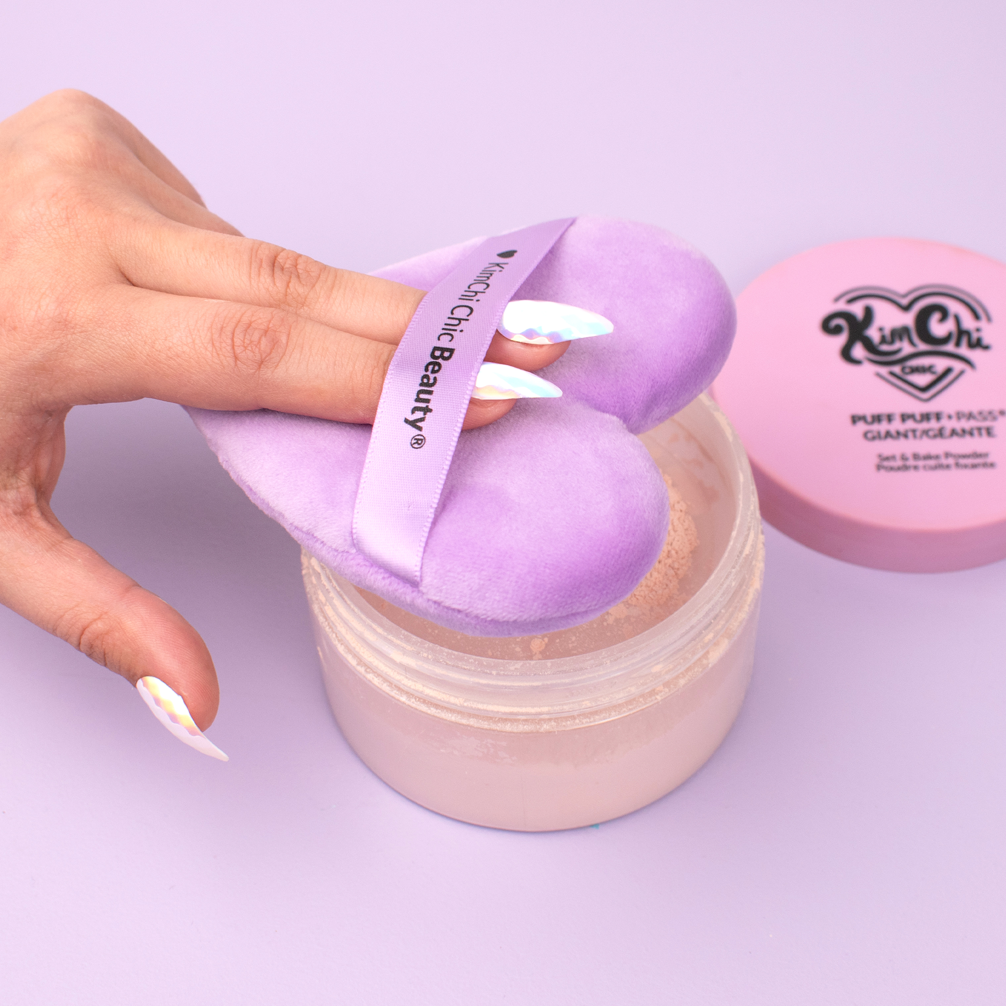 Kim Chi Beauty Puff Puff in pink jar with lavender puff applicator for soft baking makeup.