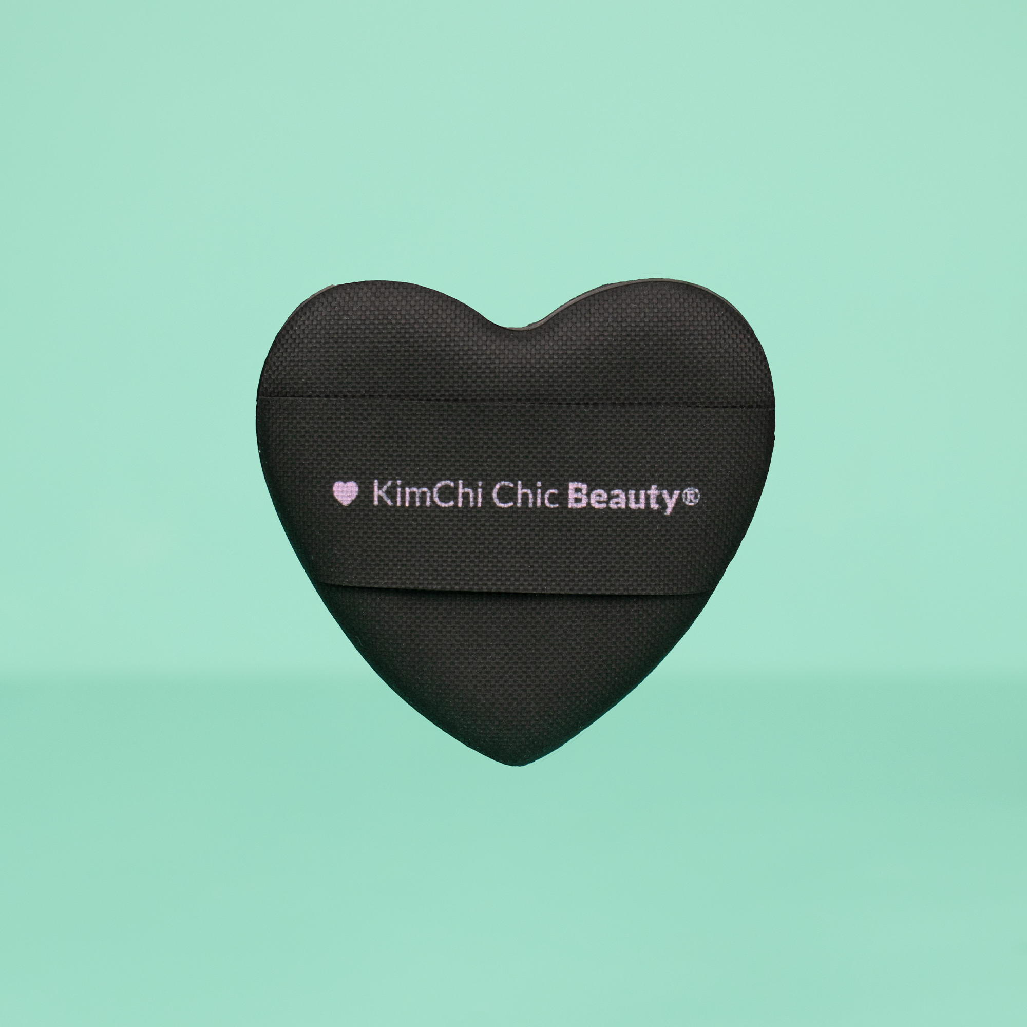 Black heart-shaped makeup sponge by KimChi Chic Beauty for flawless application.