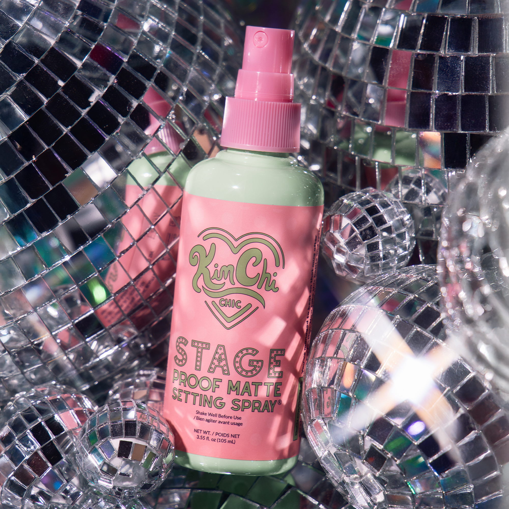 Kim Chi Stage Proof Matte Setting Spray in pink and green bottle, 3.5 oz for long-lasting makeup hold.