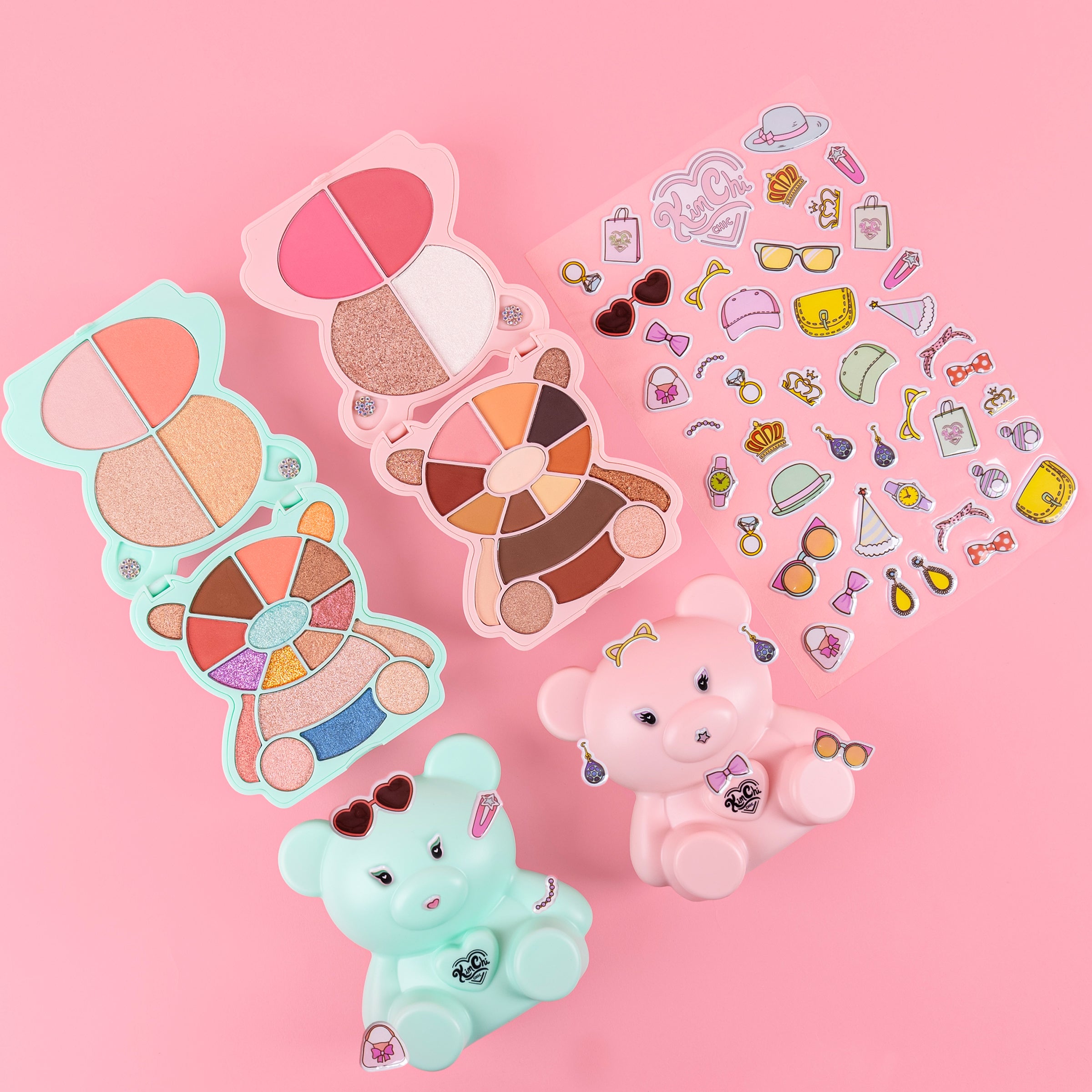 Colorful bear-shaped makeup palettes and stickers on a pink background
