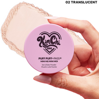 Hand holding a round container of Kim Chi Chic Puff Puff Pass Mini Bake Powder in Translucent shade.