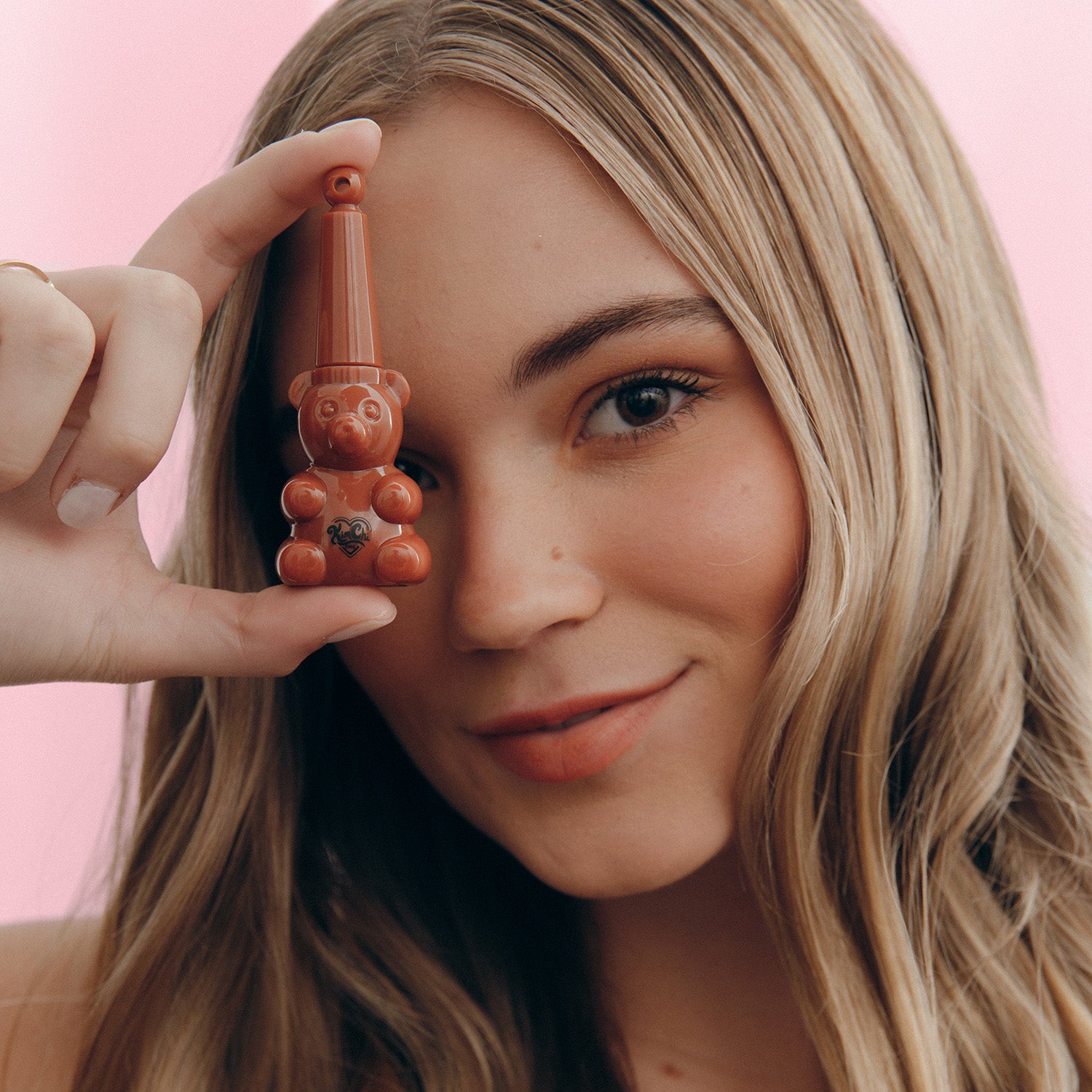 Person holding a small gnome figurine next to their face.