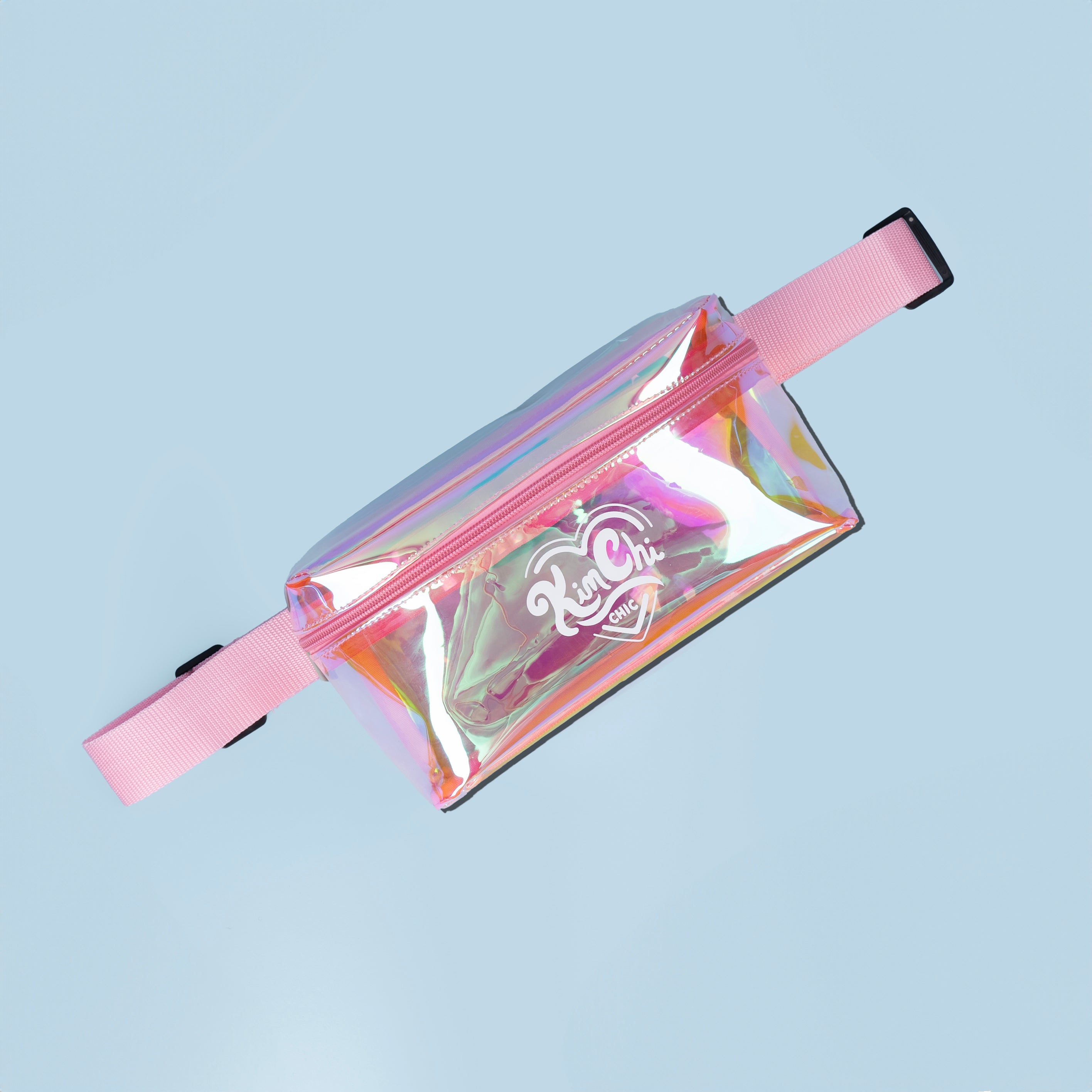 Iridescent fanny pack with pink strap on a light blue background