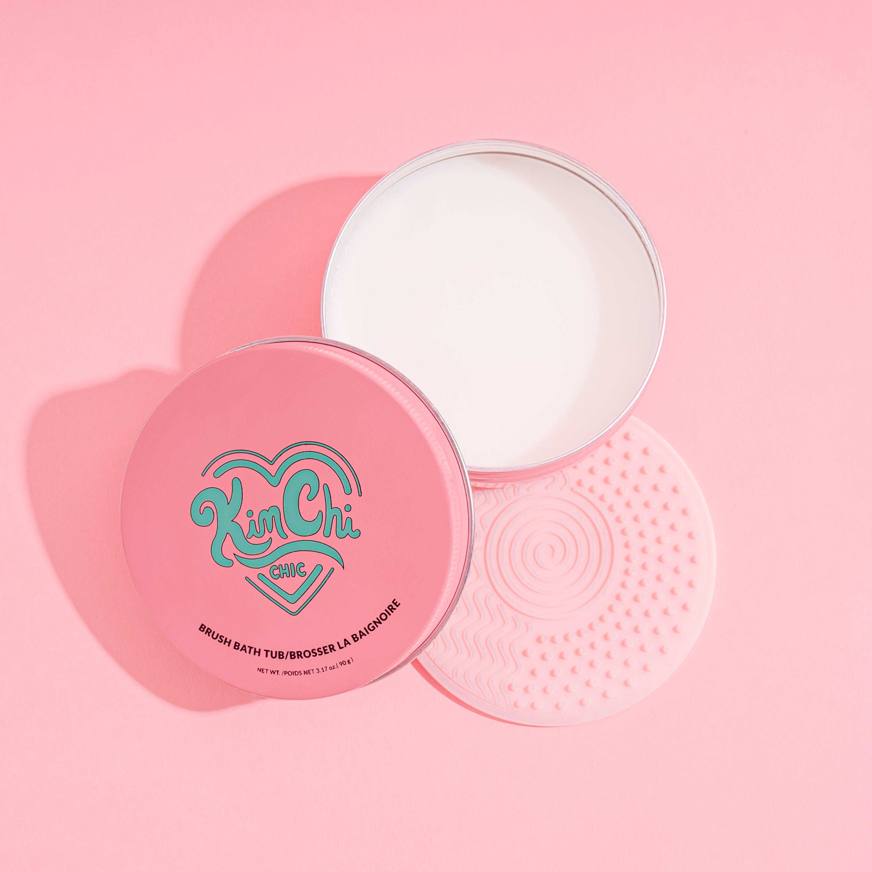 Open pink cosmetic container with heart design on lid