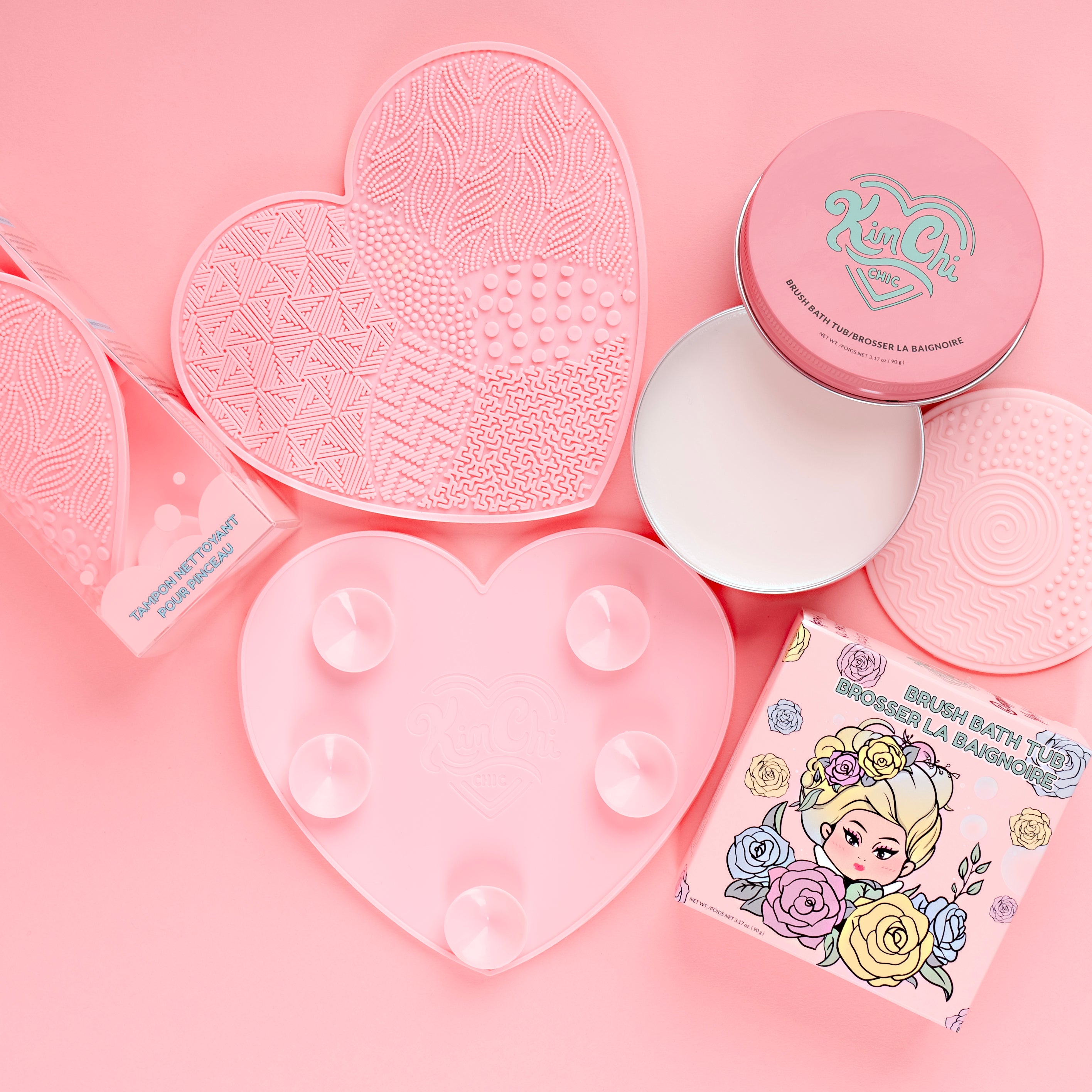 Pink cosmetic products and packaging on a pink background