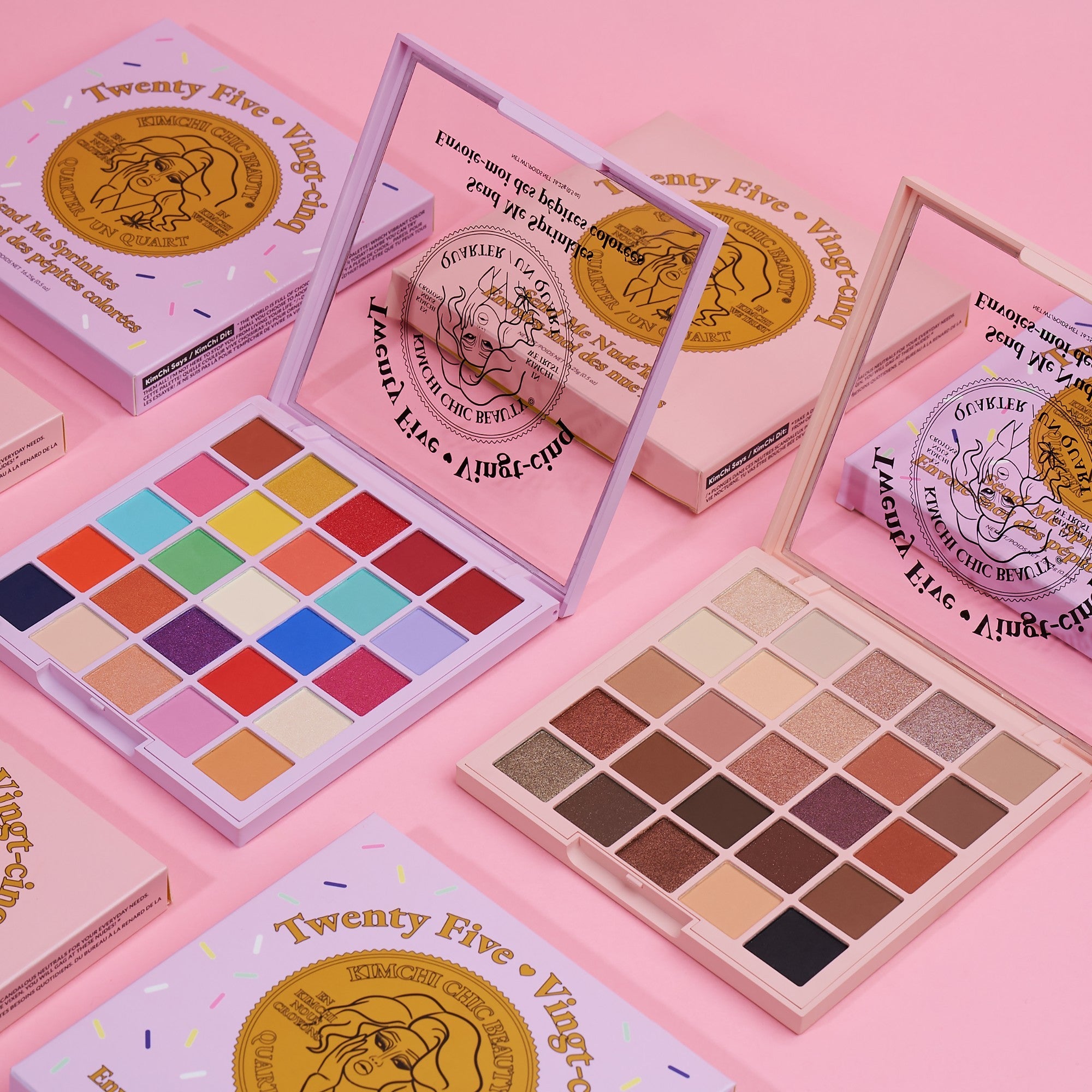Colorful eyeshadow palettes arranged on a pink background.