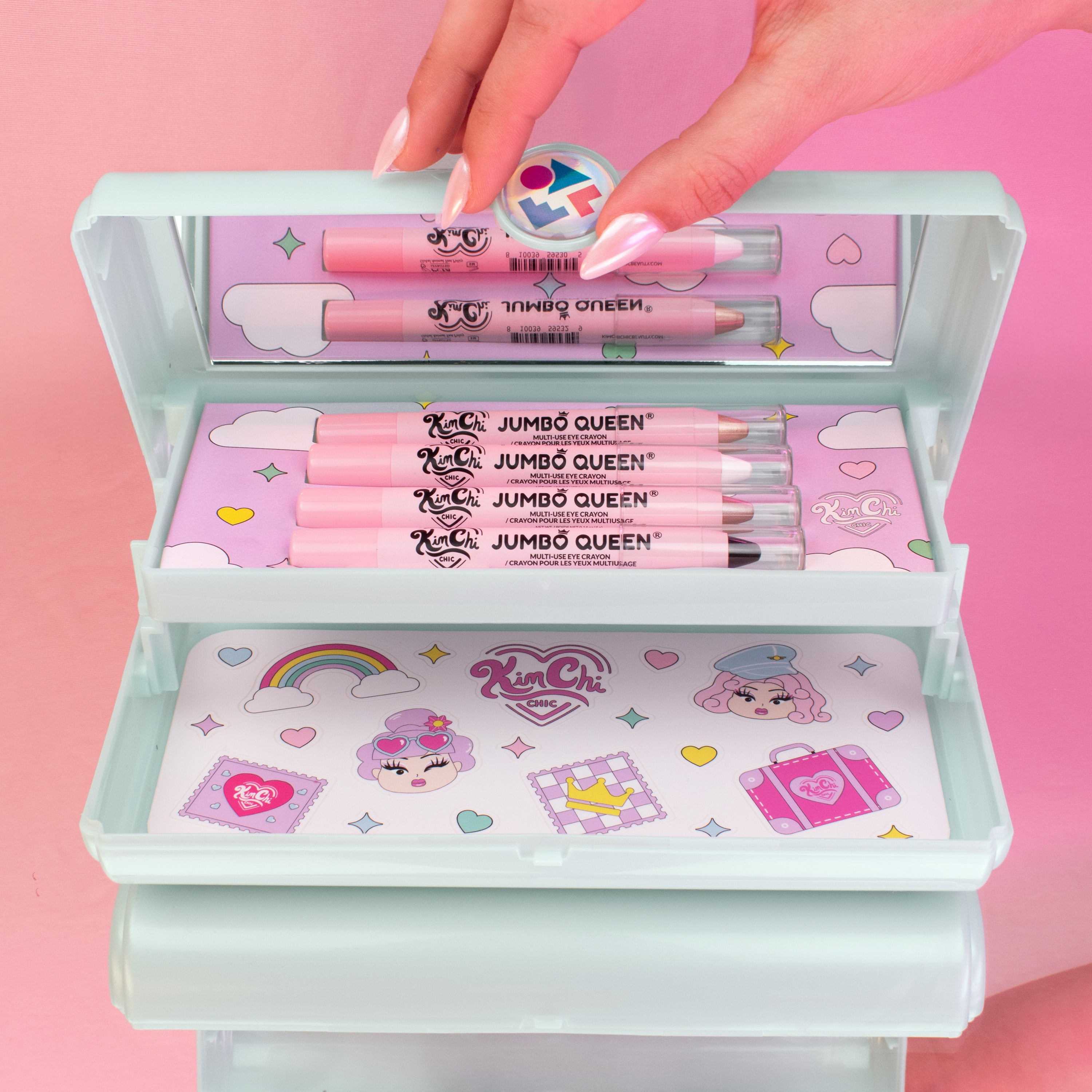 A hand opening a pastel-colored pencil case with pink pencils and colorful illustrations inside.