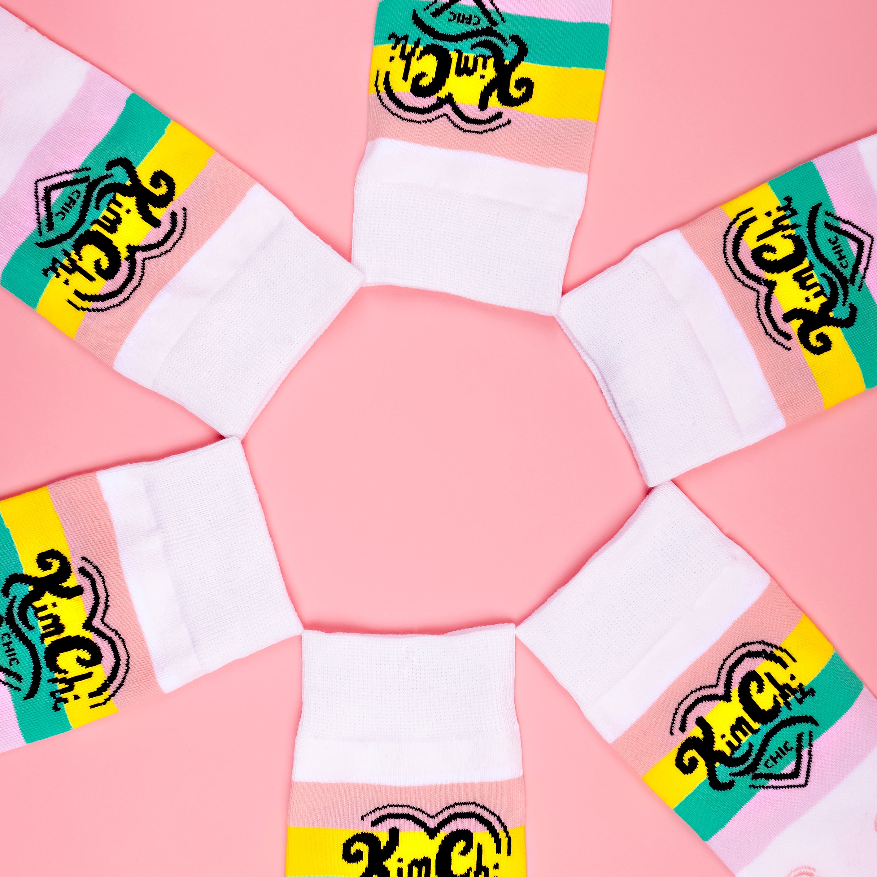 Colorful socks arranged in a circle on a pink background