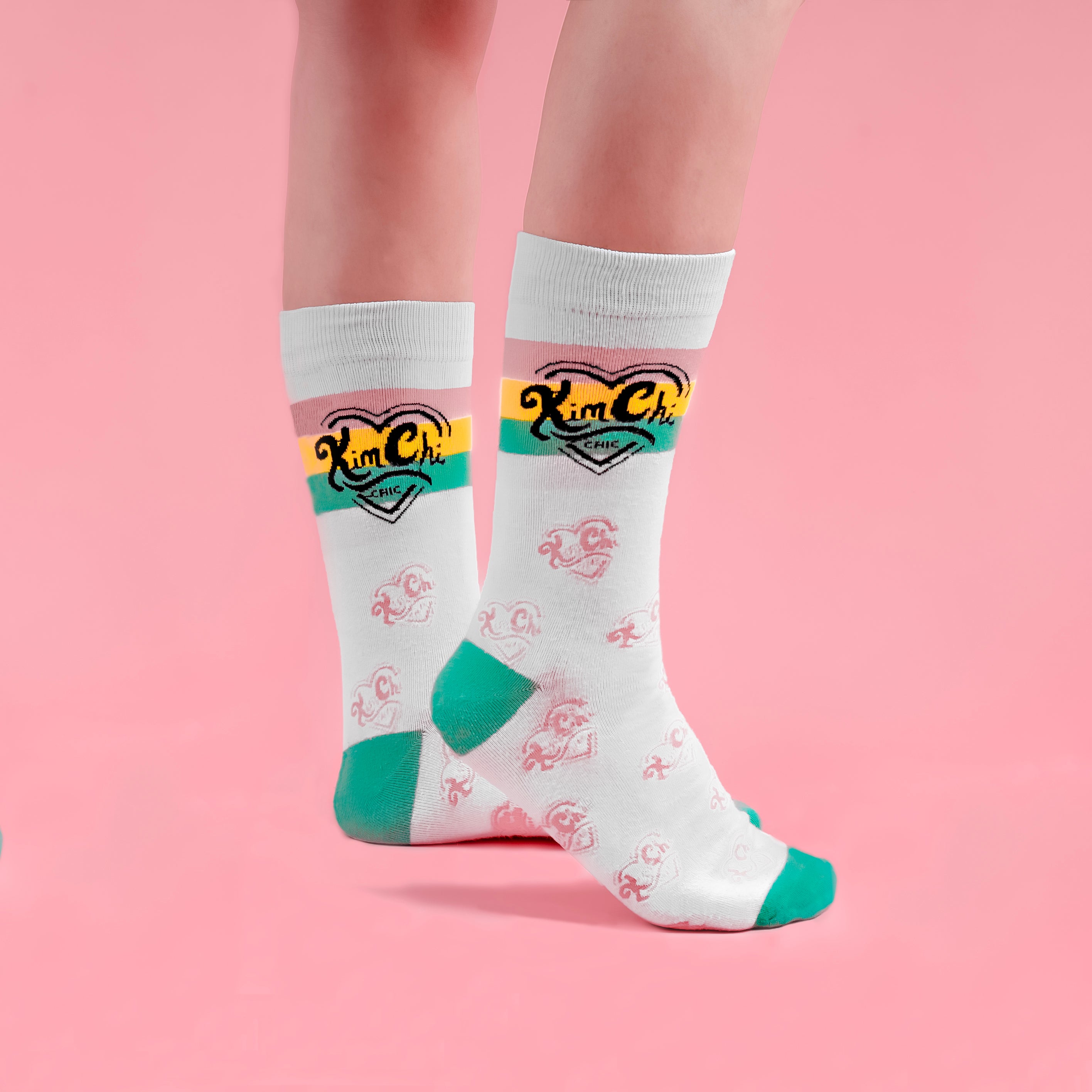 Person wearing white socks with green accents and kimchi logo.