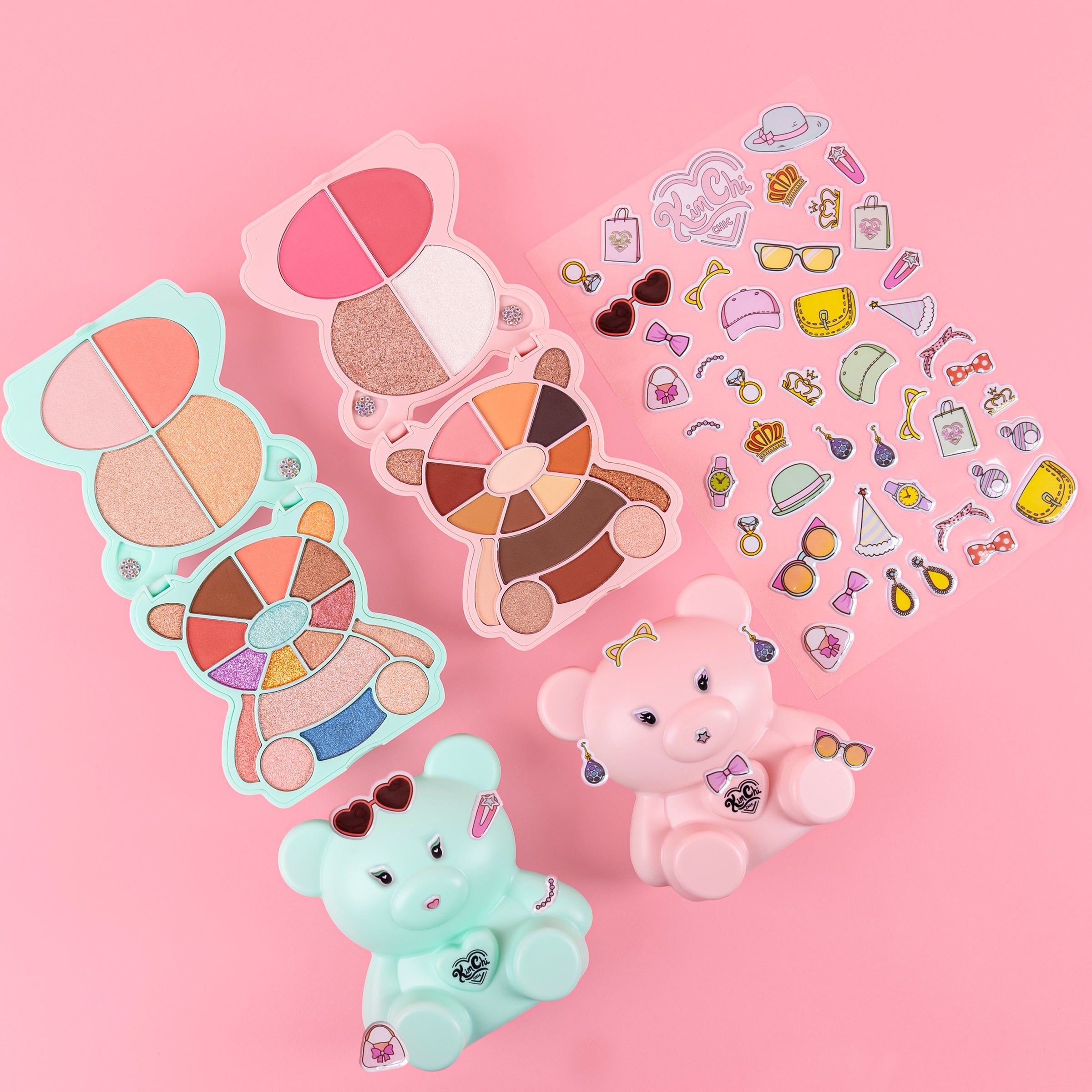 Colorful bear-shaped makeup palettes and stickers on a pink background