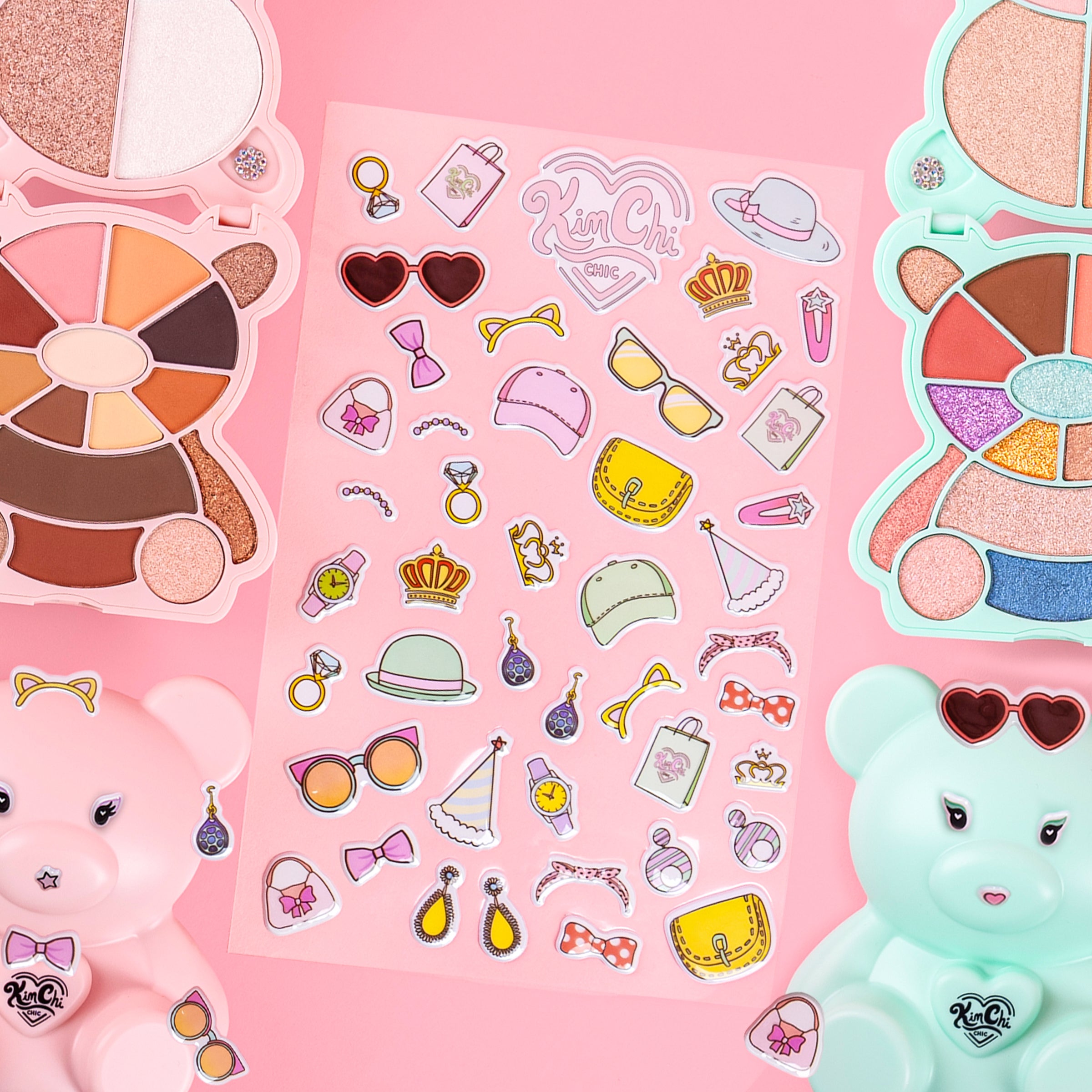 Colorful makeup palettes and stickers on a pink background with bear designs.