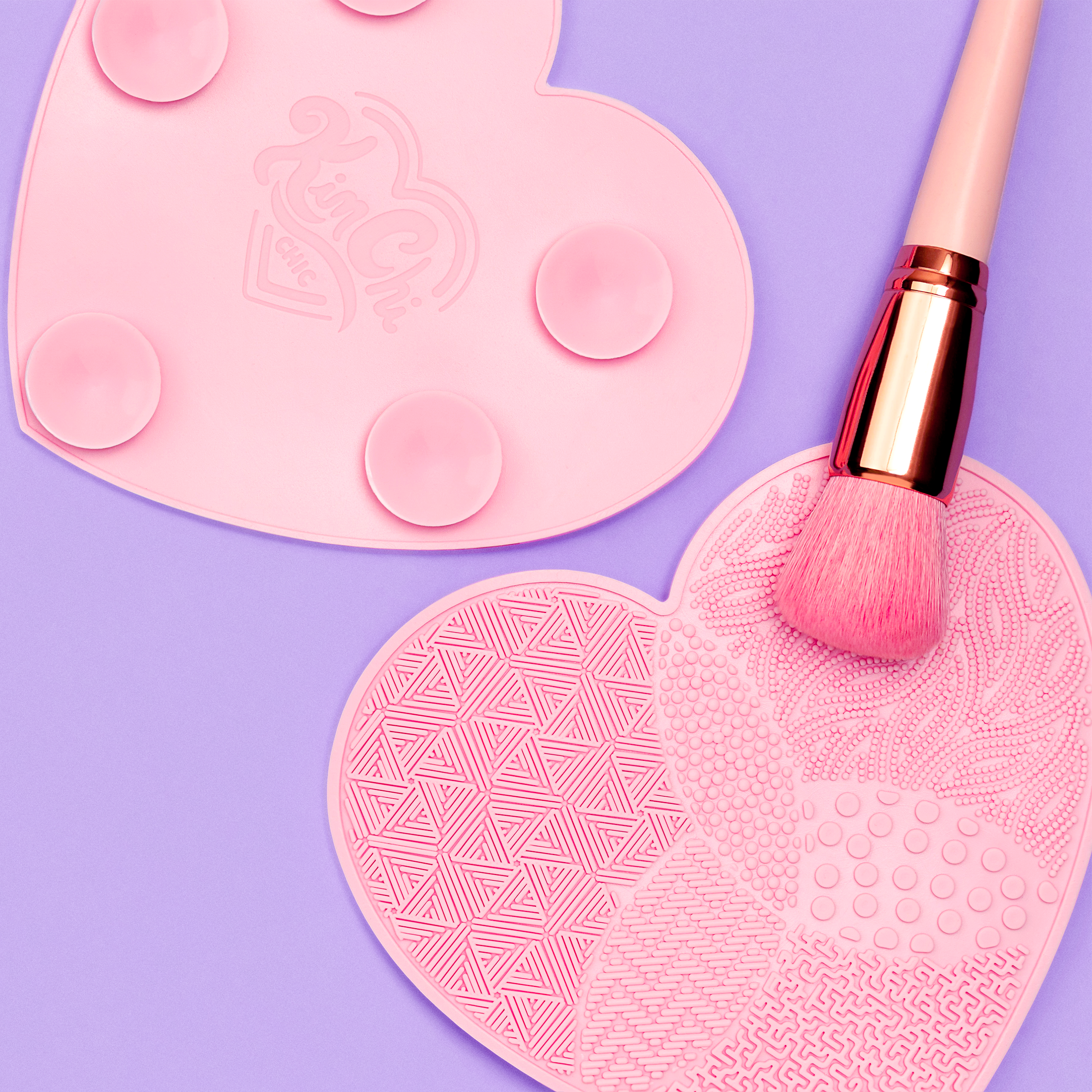 Pink heart-shaped makeup brush cleaning mat with brush