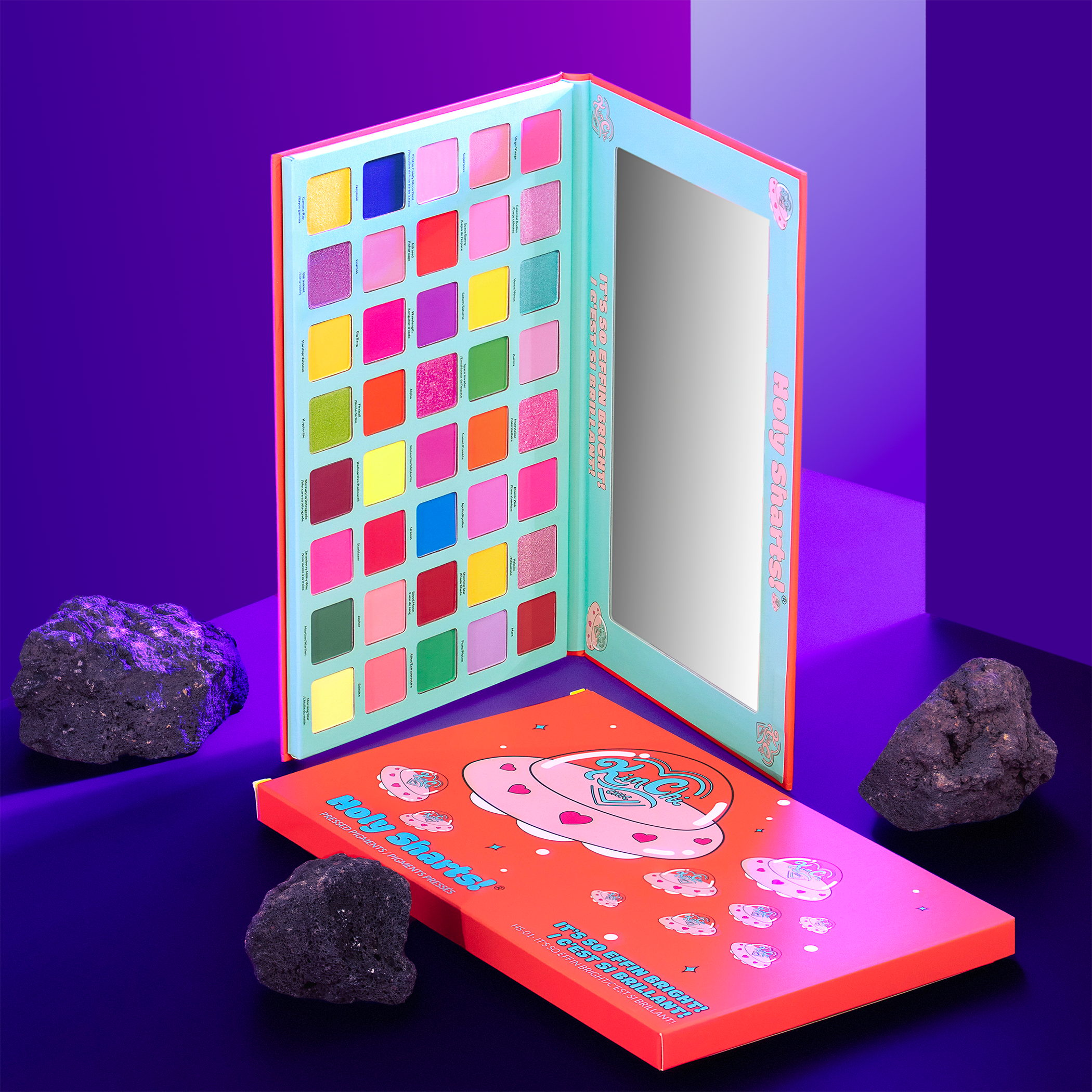 Colorful eyeshadow palette with mirror and rocks on a purple background