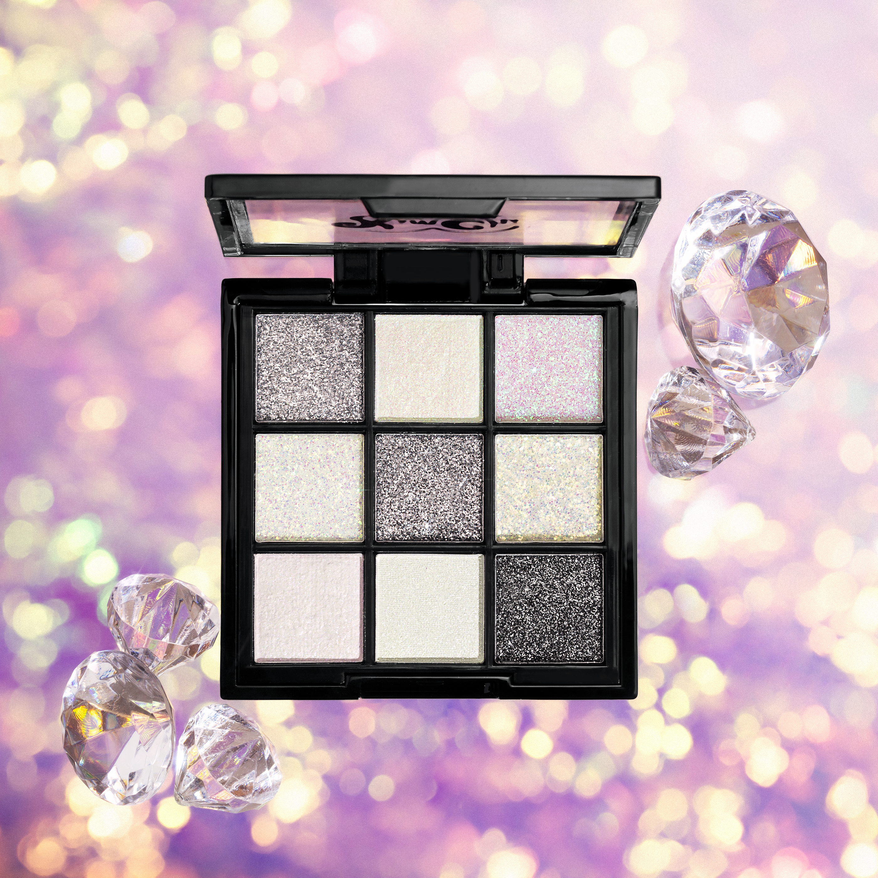 Shimmery eyeshadow palette with diamonds on a sparkling background.