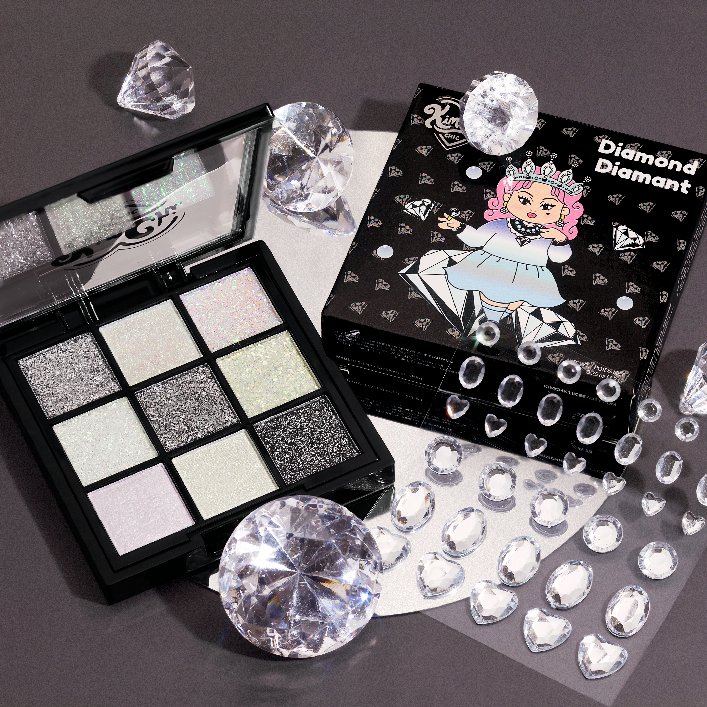 Glittery eyeshadow palette with decorative rhinestones and packaging.