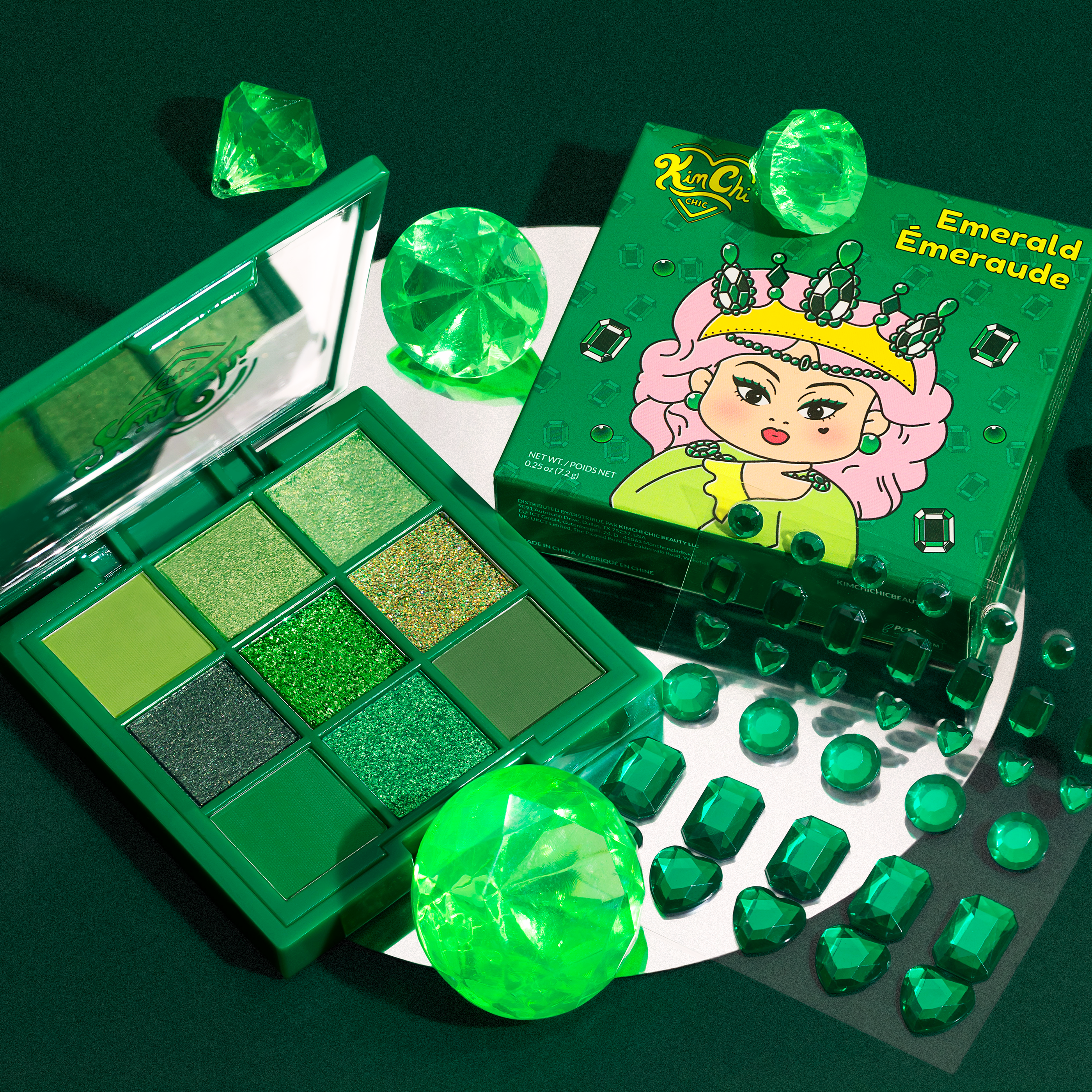 Green-themed makeup palette with packaging and decorative gems