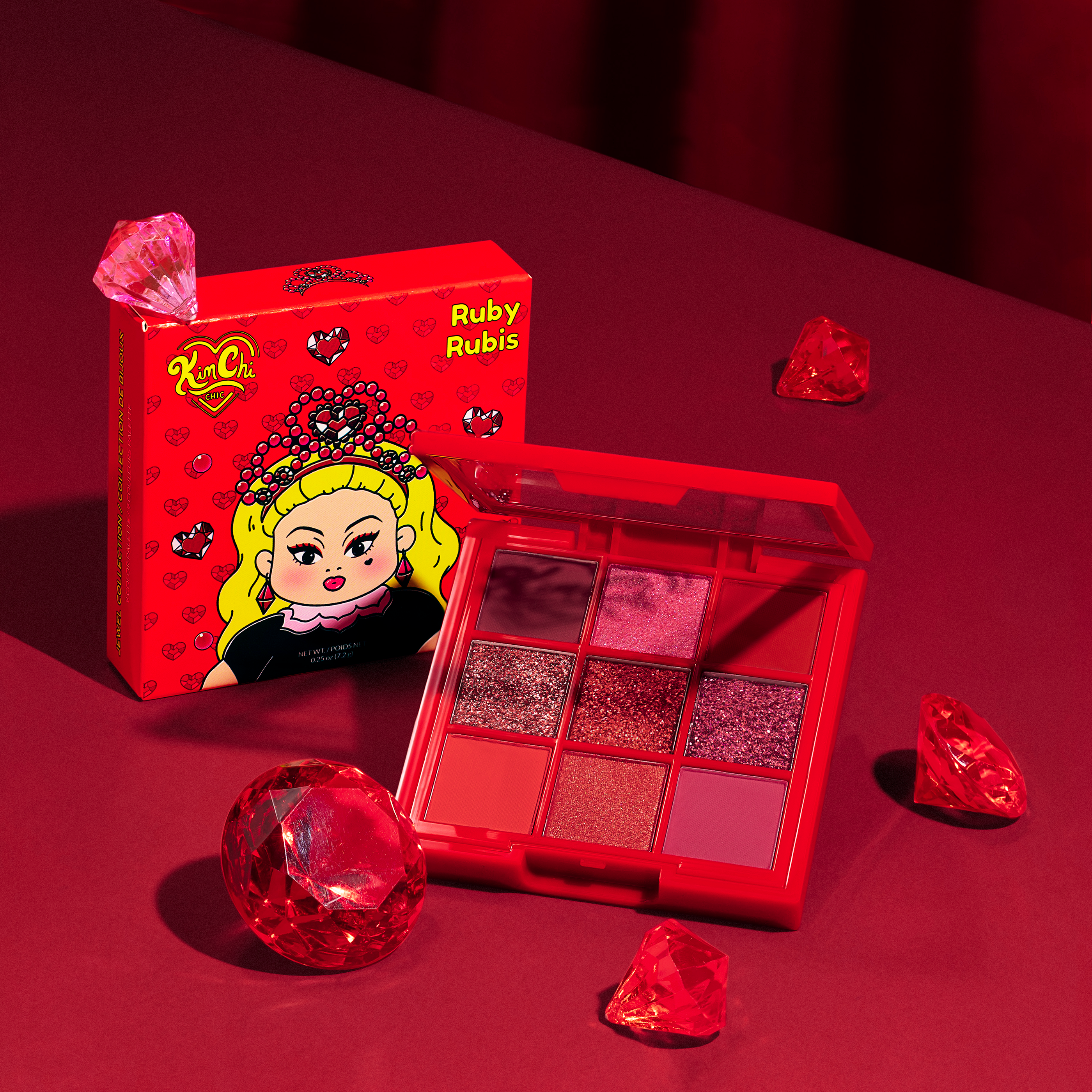 Red-themed makeup palette with vibrant colors, surrounded by ruby-like gems.