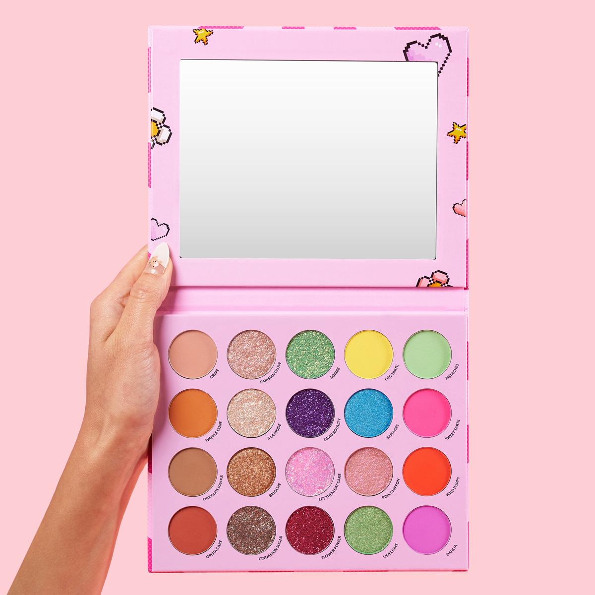 Hand holding a colorful eyeshadow palette with mirror