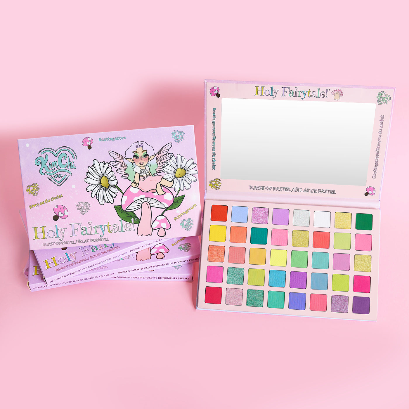 Colorful eyeshadow palette with fairy-themed packaging on a pink background.