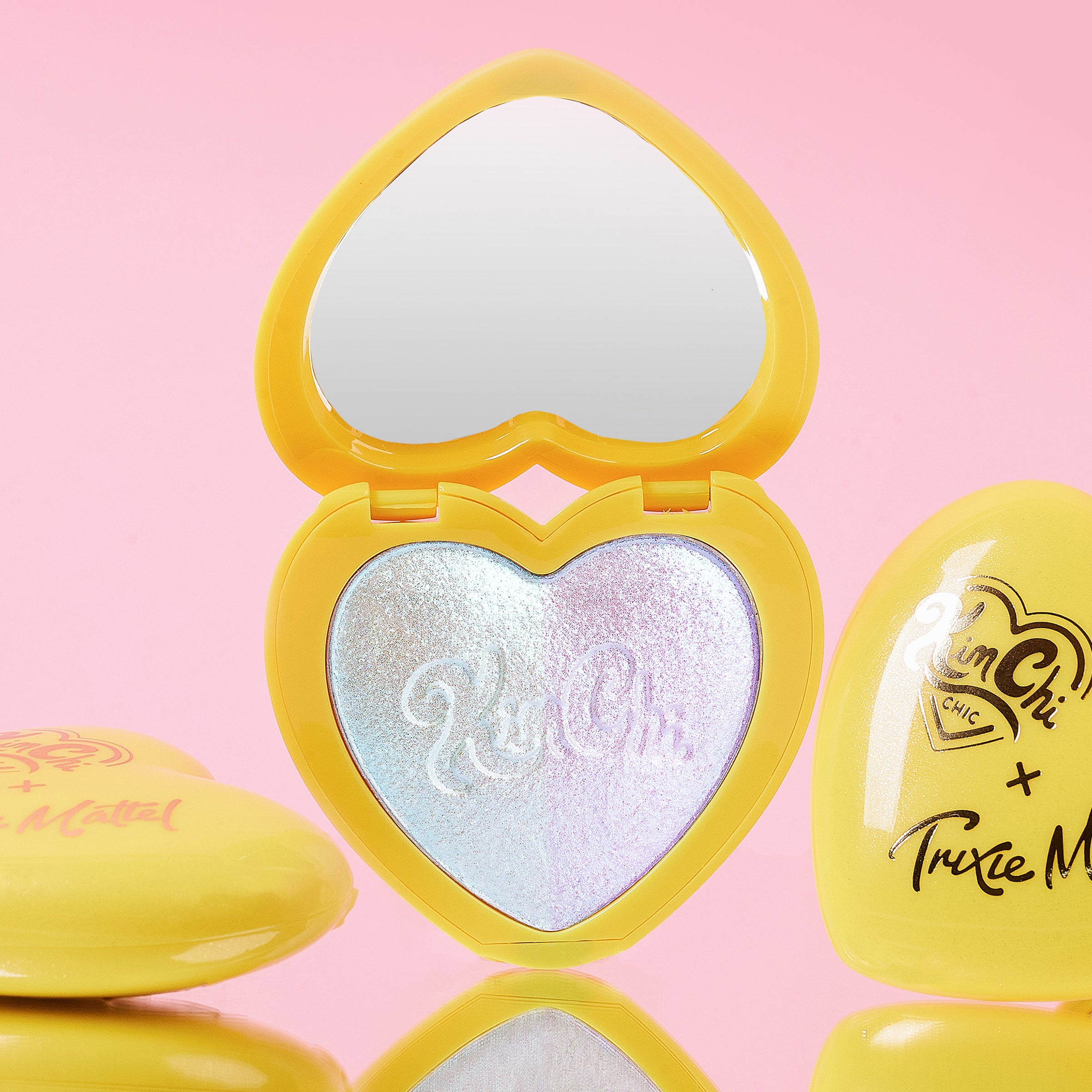 Heart-shaped makeup compact with mirror and shimmering highlighter